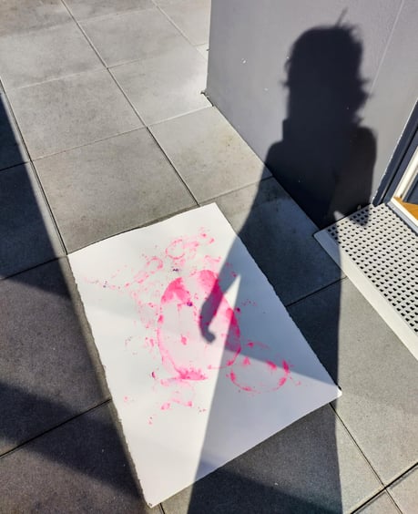 photo de l'ombre de l'artiste sur son œuvre à l'aquarelle rose