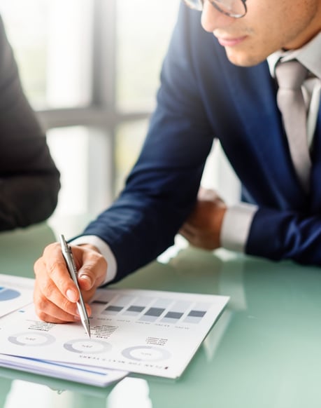 a man in a suit and tie is writing on a paper