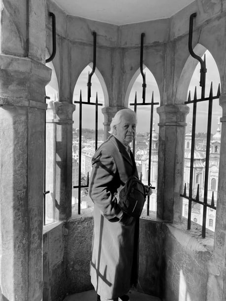 a man in a coat and hat standing in a tower