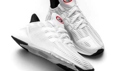 a pair of white sneakers with a red and black shoelace