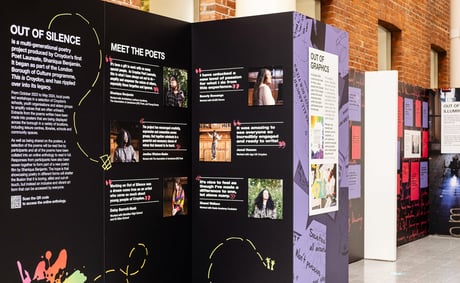 an exhibition display of photos and text on black and purple backgrounds