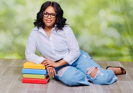a woman sitting on a wooden floor with books