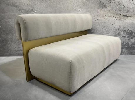Modern bench with plush cream cushions and gold metal back, by Solo Home Decor.