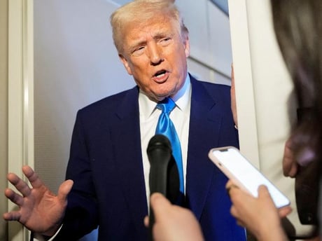 a man in a suit and tie is talking to a reporter