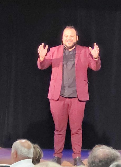 a man in a suit and tie standing on a stage