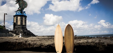 Two handmade balsa surfboards standing on coastal rocks in Bali