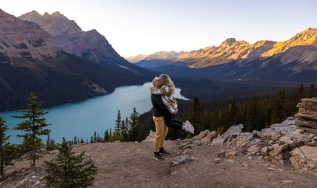 a couple standing on a mountain top with Peyto Lake in the background