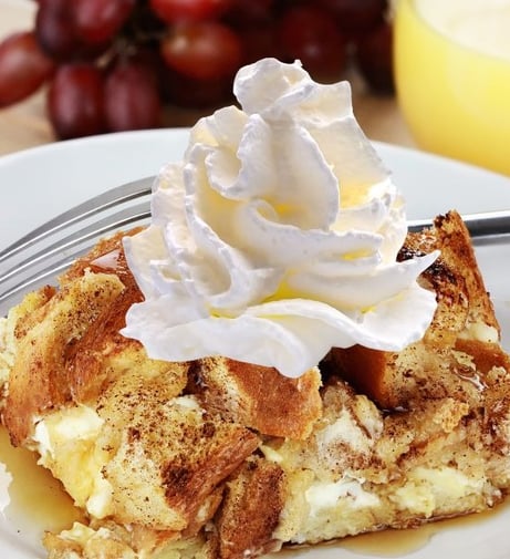 a piece of bread pudding with whipped cream on top of it