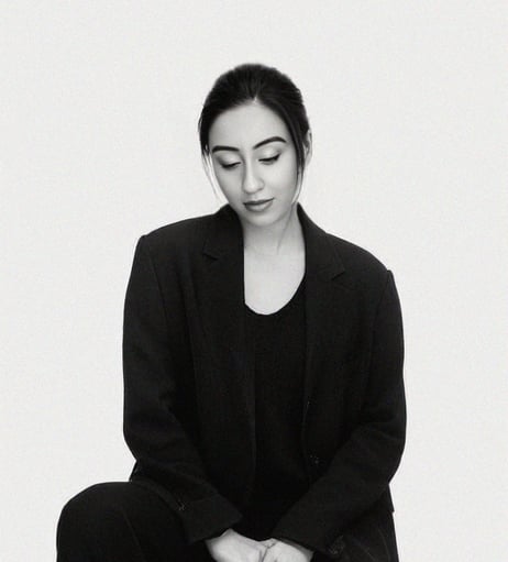 a wedding photoghrapher sitting on a stool with her eyes closed