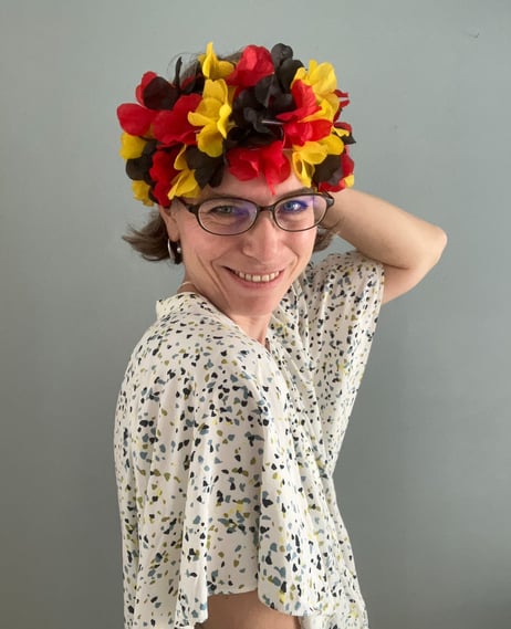 a woman wearing a crown with colours of the German flag and glasses