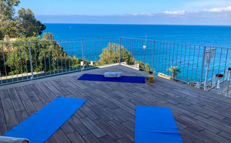 yoga class on terrace at hotel kalura in sicily facing the sea - yoga mats for asana