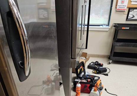 technician is repairing temperature inconsistencies in a commercial freezer in Charlotte