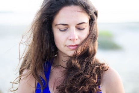a woman in a blue dress is looking down at her cell phone