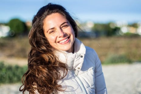 a woman with long hair and a white jacket