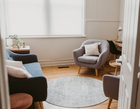 a consulting room in bright light with a chair and a couch