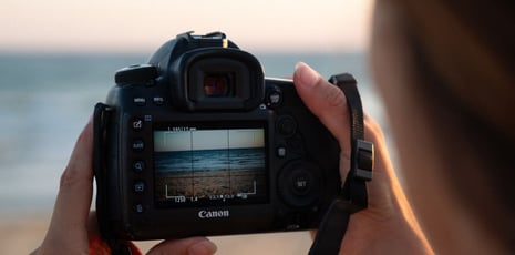 a person holding a camera and taking a picture of a camera