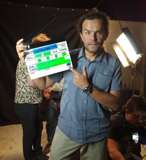 Cristian Laverde holding a camera and pointing at a camera