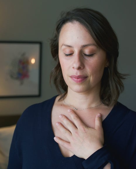 a photo of a woman with her eyes closed and hand on her chest