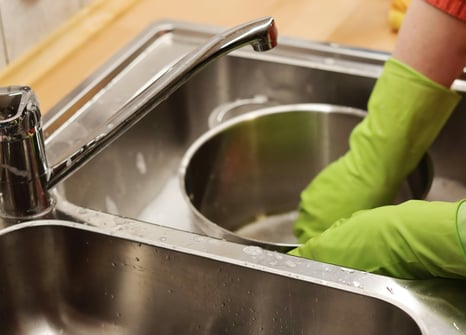 kid washing dishes in the sink