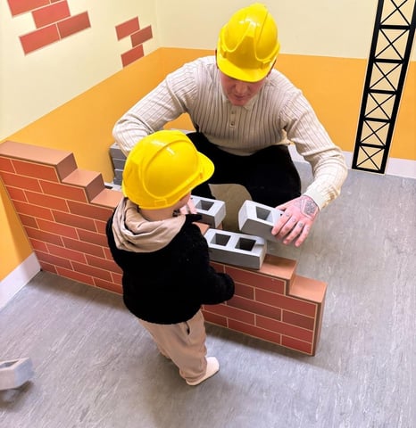 L&G Home Solutions with his young son, wearing builder hats – a family-run business in Lancing