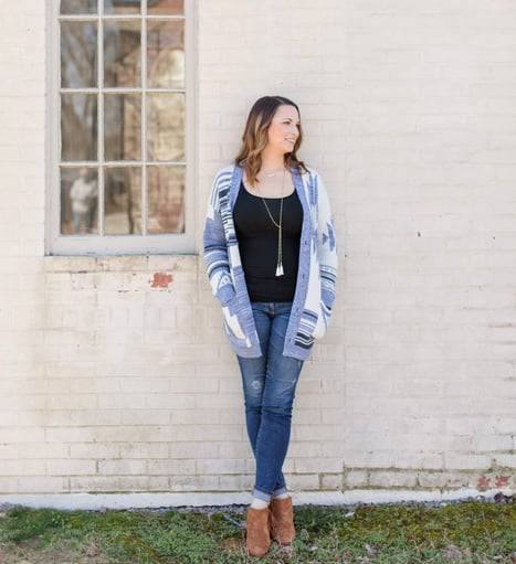Hana Maren Godfrey standing in front of a white brick wall