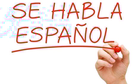 a hand writing spanish words on a white board