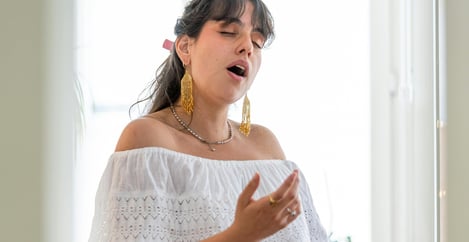 Une jeune femme chante pendant un cours de chant