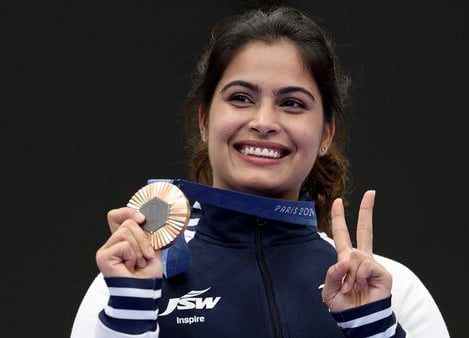 a woman holding a medal and a medal