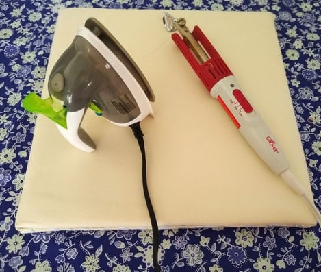 "DIY portable ironing board with a mini steam iron and a Clover craft iron resting on top, displayed