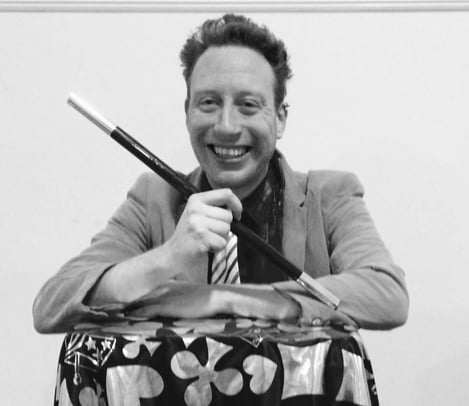 a man in a suit and tie is smiling and holding a knife and knife