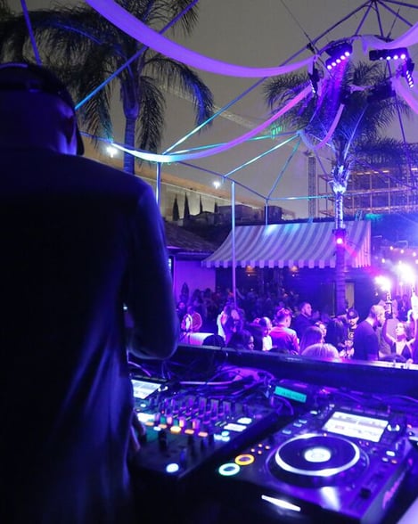 DJ Set with Purple Lights at Outdoor Club with Palm Trees