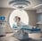 Medical professionals are performing surgery in an operating room equipped with overhead lights and medical equipment. IV bags are visible, and the team is focused on the patient lying on the operating table.