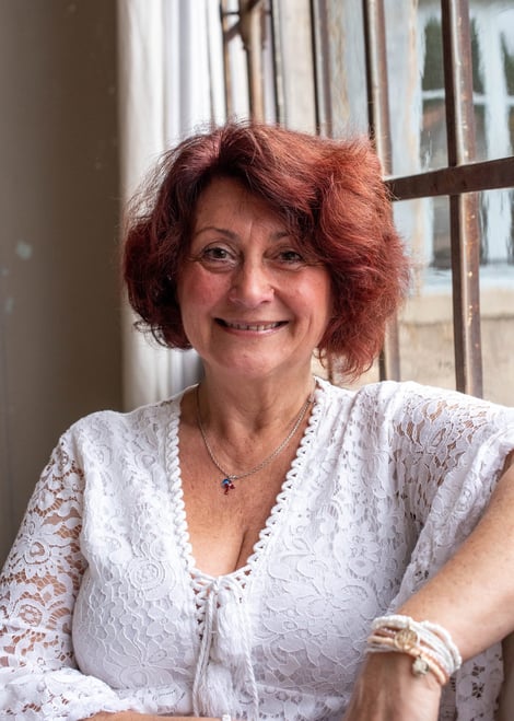 Portrait lumineux de Flo Salort en tunique blanche, sourire doux représentant le leadership 