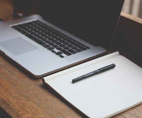 a pen and notebook on a desk. Key tools for Content Writing. 