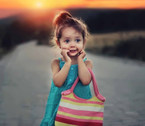 small girl with purse on dirt country road