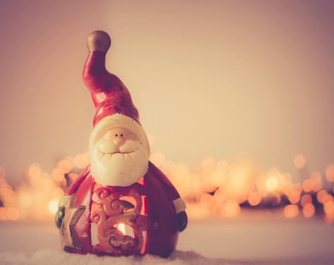 An image of Santa Claus flying through the night sky with his reindeer, delivering gifts to children