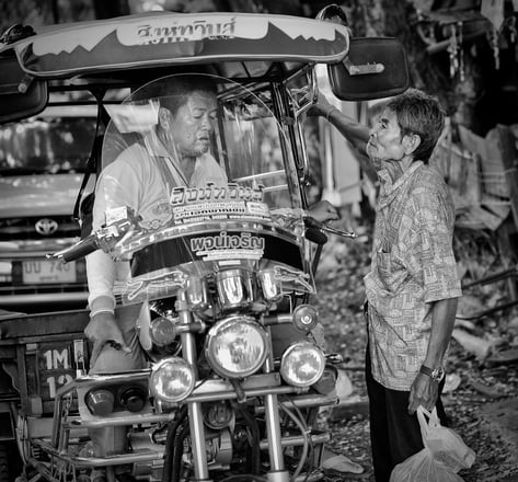 Skylab driver discussing fare with passenger in Thailand - street photography by Peter Pickering