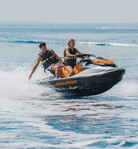 Happy couple riding a jet ski in Mallorca’s turquoise waters