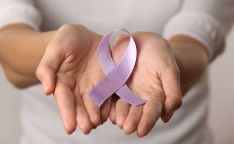 a person holding a purple ribbon with a purple ribbon