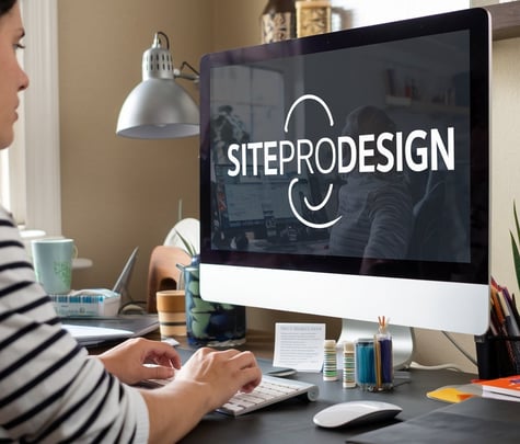 a woman sitting at a desk with a computer screen displaying a websitepage