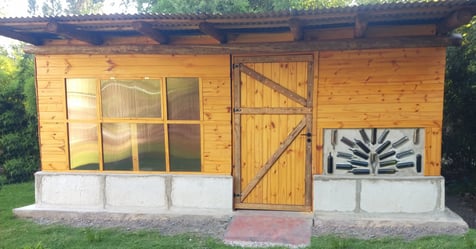 a small wooden cabin with a door and a window