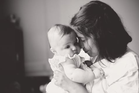 portrait en noir et blanc d’une maman tenant son bébé, moment doux et intime