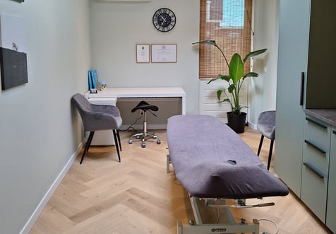een kamer met een behandelbank en bureau