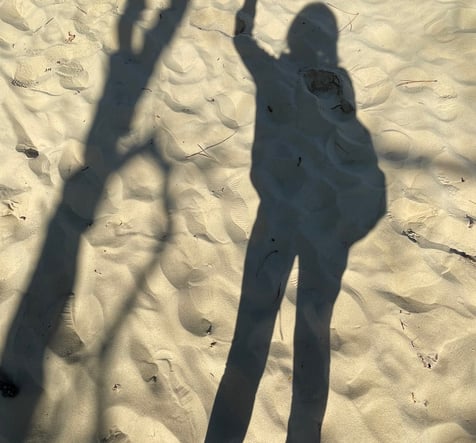 photo représentant l'ombre d une personne sur du sable