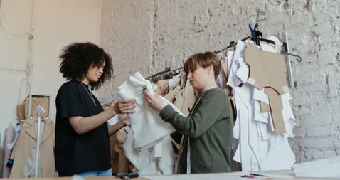 Ethical garment manufacturing workers assembling apparel in clean production space