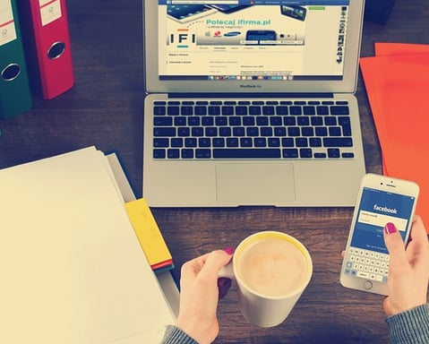 Mãos femininas com café e smartphone em mesa com laptop, Only Goods Pro 2025.