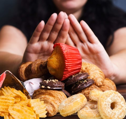 a woman is holding a pastry and a pastry