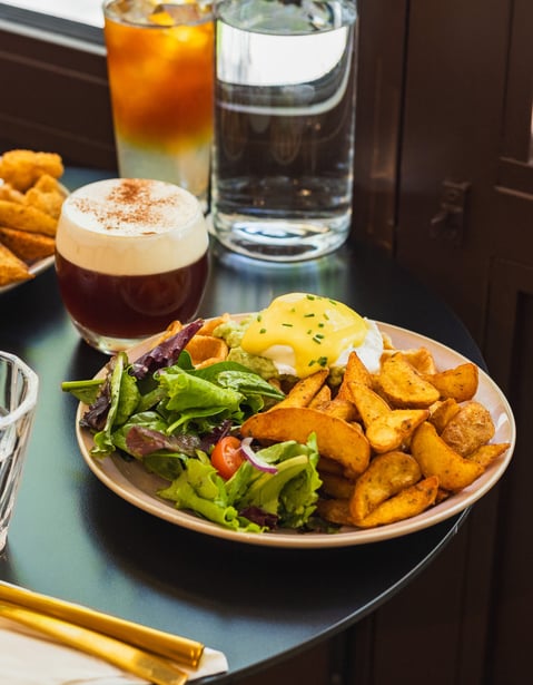 a table with a plate of food and a drink