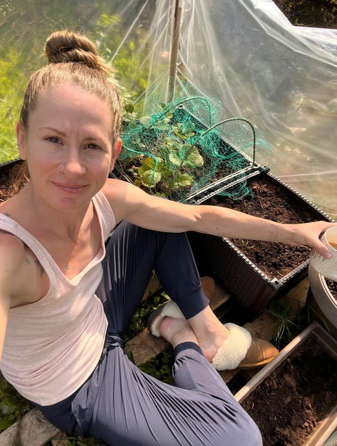 Sitting on the ground inside a green house. 