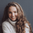 a woman with long hair and a white sweater